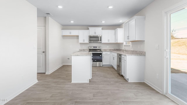 kitchen featuring recessed lighting, a sink, appliances with stainless steel finishes, white cabinetry, and light wood-type flooring
