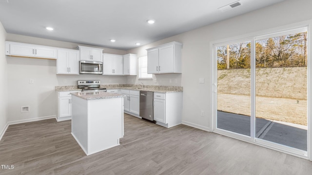 kitchen with visible vents, light wood-style flooring, a sink, appliances with stainless steel finishes, and white cabinetry