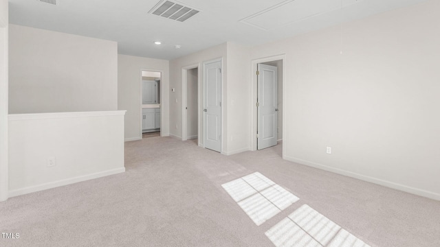 interior space featuring visible vents, baseboards, attic access, light carpet, and recessed lighting