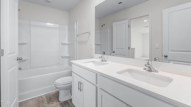 bathroom featuring a sink, visible vents, toilet, and wood finished floors