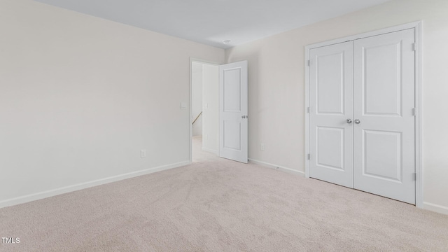 unfurnished bedroom featuring a closet, baseboards, and carpet