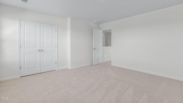 unfurnished bedroom with visible vents, carpet, baseboards, and a closet