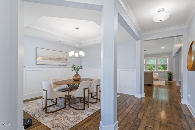 dining room with ornamental molding, wainscoting, and dark wood finished floors