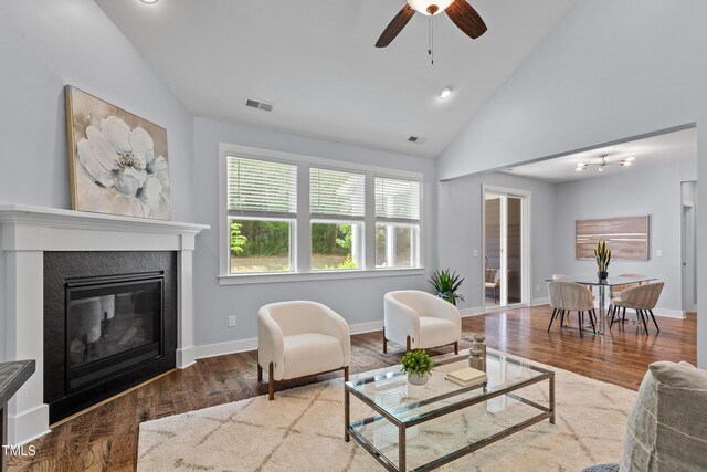 living area with vaulted ceiling, wood finished floors, and visible vents