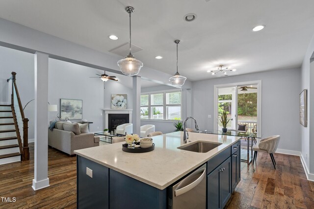 kitchen featuring a fireplace, ceiling fan, a sink, dishwasher, and decorative light fixtures