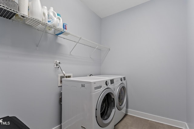 laundry room with baseboards, laundry area, and separate washer and dryer