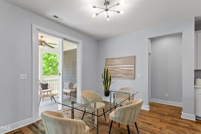 dining area with baseboards, a notable chandelier, wood finished floors, and visible vents
