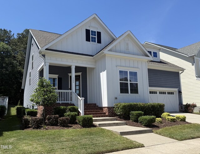 1564 Highpoint St, Wake Forest, NC 27587 - view of front of home with board and batten siding, covered porch, driveway, and a garage