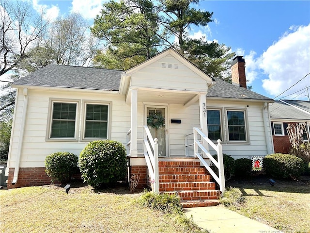 bungalow with central air condition unit, a chimney, and a shingled roof