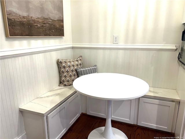 dining area with breakfast area and a wainscoted wall