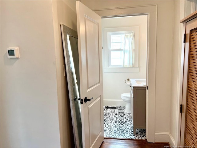 bathroom with baseboards, toilet, and vanity