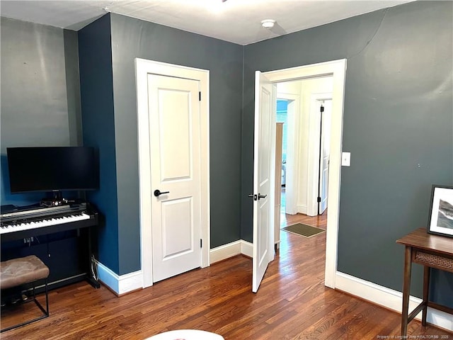 living area with baseboards and wood finished floors