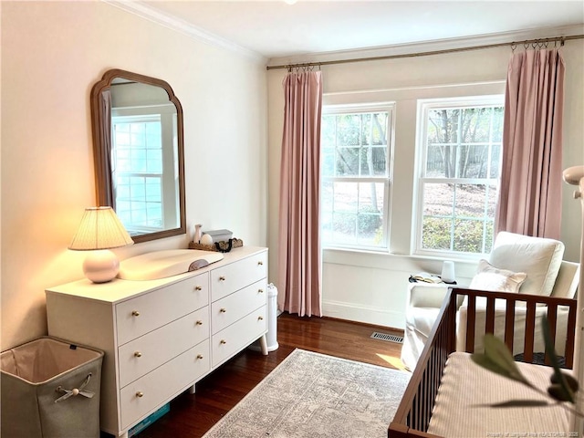 bedroom with crown molding, visible vents, dark wood-style flooring, and baseboards