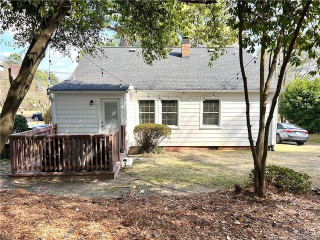 back of property with crawl space, a wooden deck, a chimney, and a shingled roof