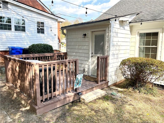 exterior space featuring a shingled roof and a deck