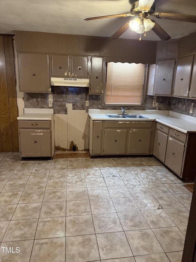 kitchen featuring a sink, decorative backsplash, under cabinet range hood, and a ceiling fan