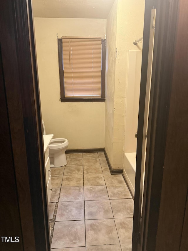 full bath with vanity, baseboards, tile patterned flooring, shower / washtub combination, and toilet