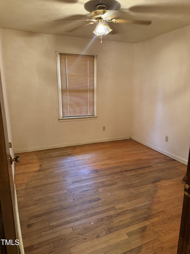 unfurnished room featuring baseboards, wood finished floors, and a ceiling fan