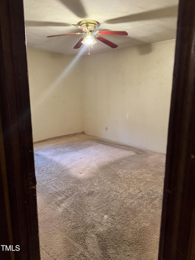 carpeted spare room featuring a ceiling fan