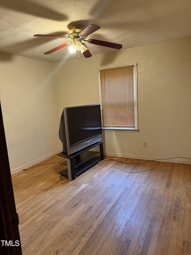 interior space featuring baseboards, wood finished floors, and a ceiling fan