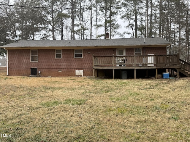 back of property featuring crawl space, a lawn, brick siding, and a deck