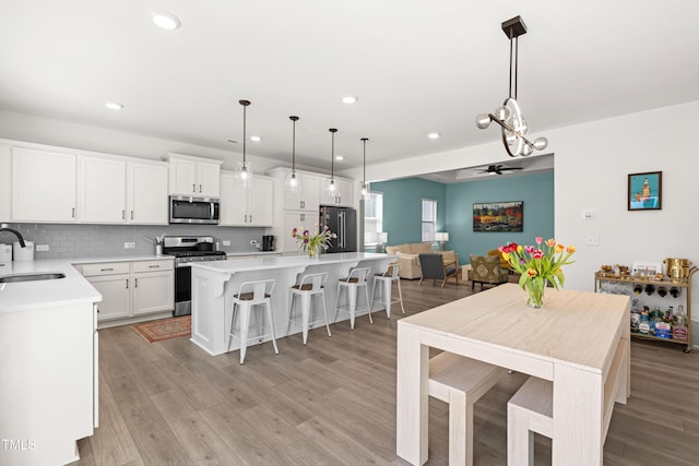 74 Silver Moon Ln, Clayton, NC 27527 - kitchen featuring light countertops, light wood-style floors, appliances with stainless steel finishes, and a sink