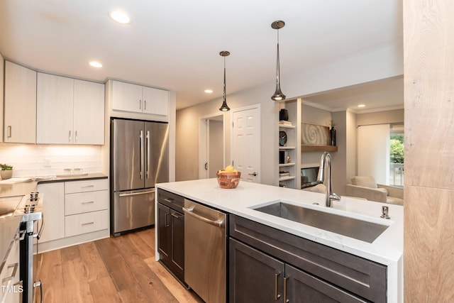 700 Bishops Park Dr Unit 205, Raleigh, NC 27605 - kitchen featuring stainless steel appliances, a sink, light wood-style flooring, decorative light fixtures, and decorative backsplash