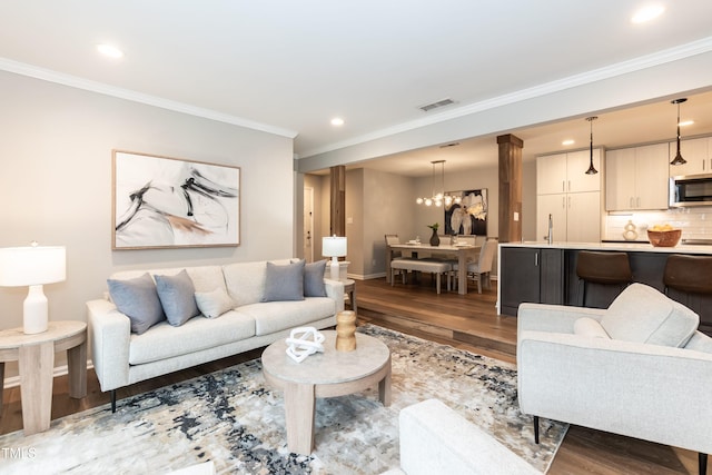 700 Bishops Park Dr Unit 205, Raleigh, NC 27605 - living room with wood finished floors, ornamental molding, recessed lighting, baseboards, and a chandelier