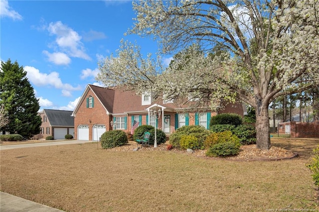 cape cod-style house with brick siding, a front lawn, an attached garage, and driveway