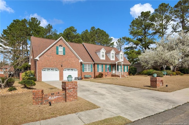 cape cod-style house with a garage, a front lawn, brick siding, and driveway