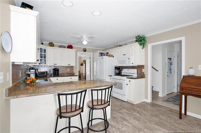 kitchen with a sink, white appliances, a peninsula, glass insert cabinets, and ceiling fan