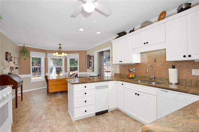 kitchen with decorative backsplash, ceiling fan with notable chandelier, a peninsula, white appliances, and a sink