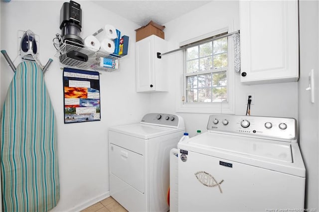 laundry area featuring washer and dryer, cabinet space, and light tile patterned flooring