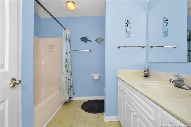 full bathroom with tile patterned floors, toilet, a textured ceiling, baseboards, and vanity