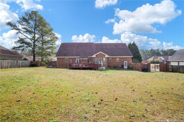 rear view of house with a yard, a fenced backyard, and a wooden deck