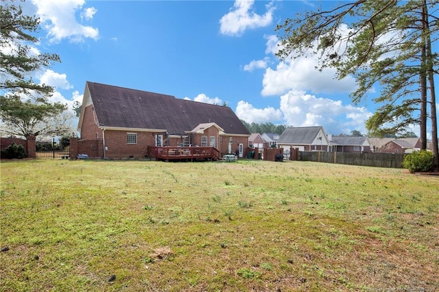 back of house featuring fence, a yard, a wooden deck, crawl space, and brick siding