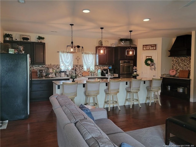 41 Lenor Dr, Lumberton, NC 28360 - kitchen with decorative backsplash, dark wood-type flooring, custom range hood, appliances with stainless steel finishes, and a kitchen breakfast bar