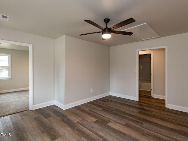 unfurnished room featuring attic access, ceiling fan, dark wood-style floors, and baseboards