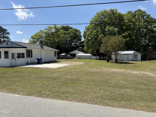 view of green lawn featuring a patio