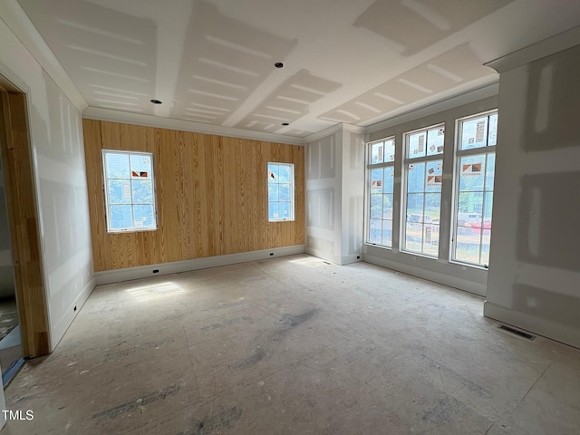 spare room with wood walls and baseboards