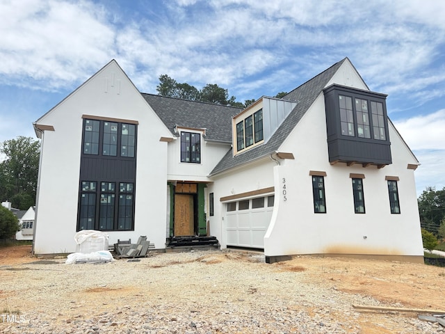 3405 Makers Cir, Raleigh, NC 27612 - modern farmhouse style home featuring roof with shingles, driveway, a garage, a standing seam roof, and stucco siding