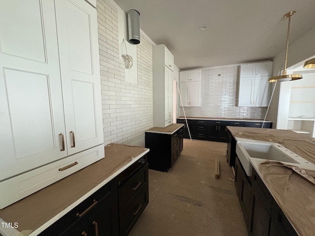 3405 Makers Cir, Raleigh, NC 27612 - kitchen featuring dark cabinets, pendant lighting, backsplash, and white cabinetry