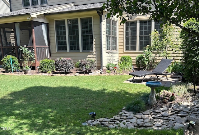 view of grassy yard with a sunroom