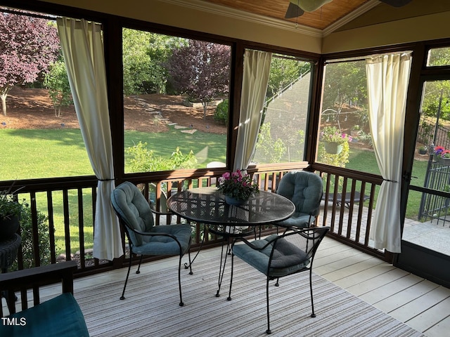 sunroom featuring vaulted ceiling, a ceiling fan, and outdoor dining space