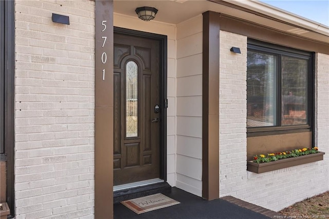 entrance to property featuring brick siding