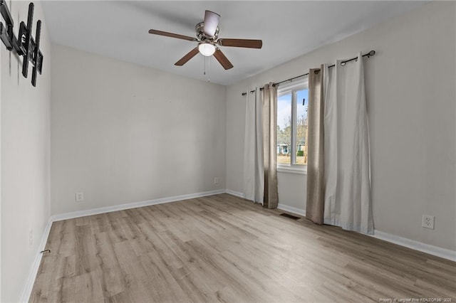 unfurnished room with baseboards, wood finished floors, and a ceiling fan