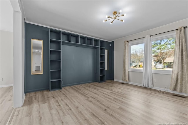 unfurnished bedroom featuring a notable chandelier, visible vents, crown molding, and wood finished floors