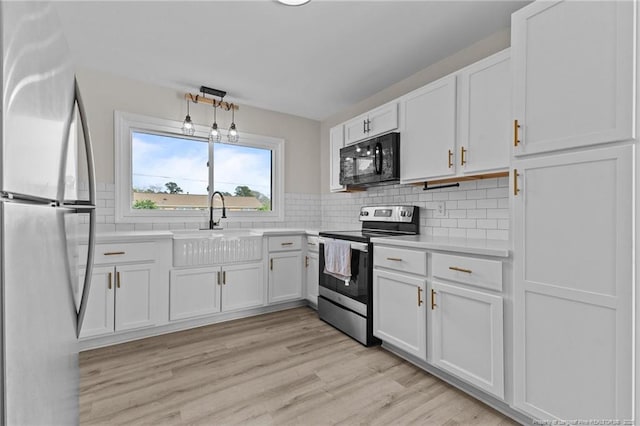 kitchen with white cabinetry, stainless steel appliances, and light countertops