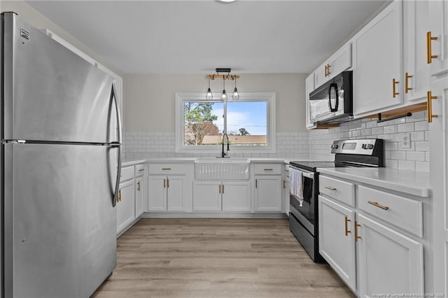 kitchen featuring white cabinetry, light countertops, appliances with stainless steel finishes, and a sink