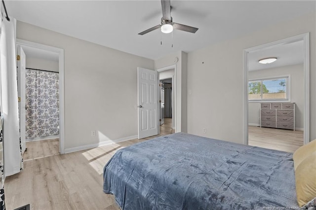 bedroom with ceiling fan, connected bathroom, baseboards, and wood finished floors